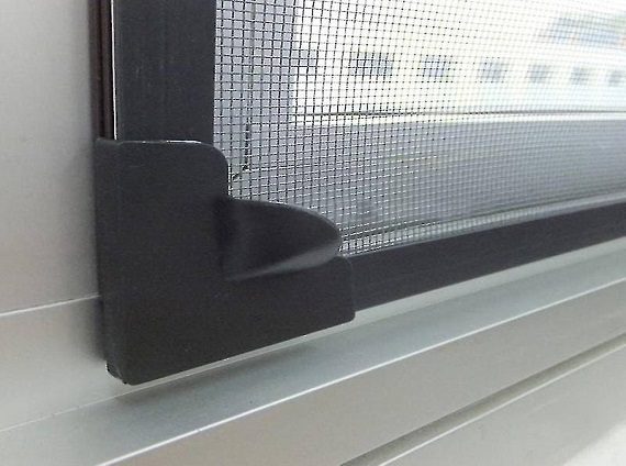 A completed DIY mesh window installed in a wooden frame, showcasing fine mesh material designed to keep insects out while allowing air to flow through.