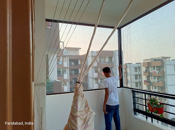 A close-up image of a mosquito net securely fitted across a balcony entrance, providing protection against insects while allowing fresh air to circulate.