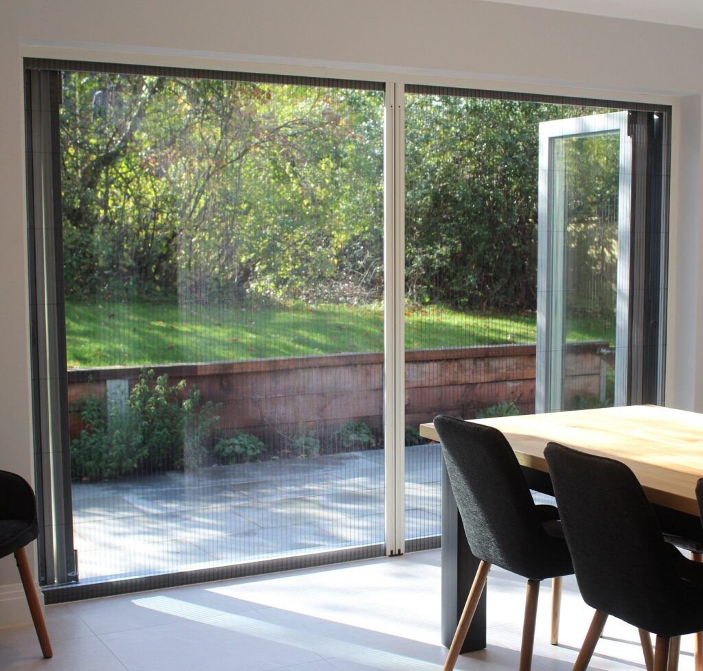 a dining table and chairs in a room with a glass door